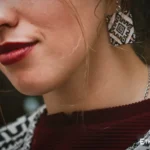 Model wearing handmade green carved earrings