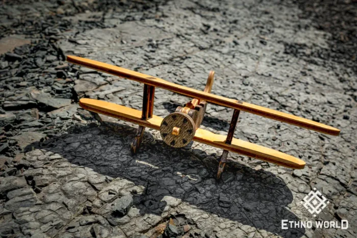 Handmade wooden biplane model on stone background